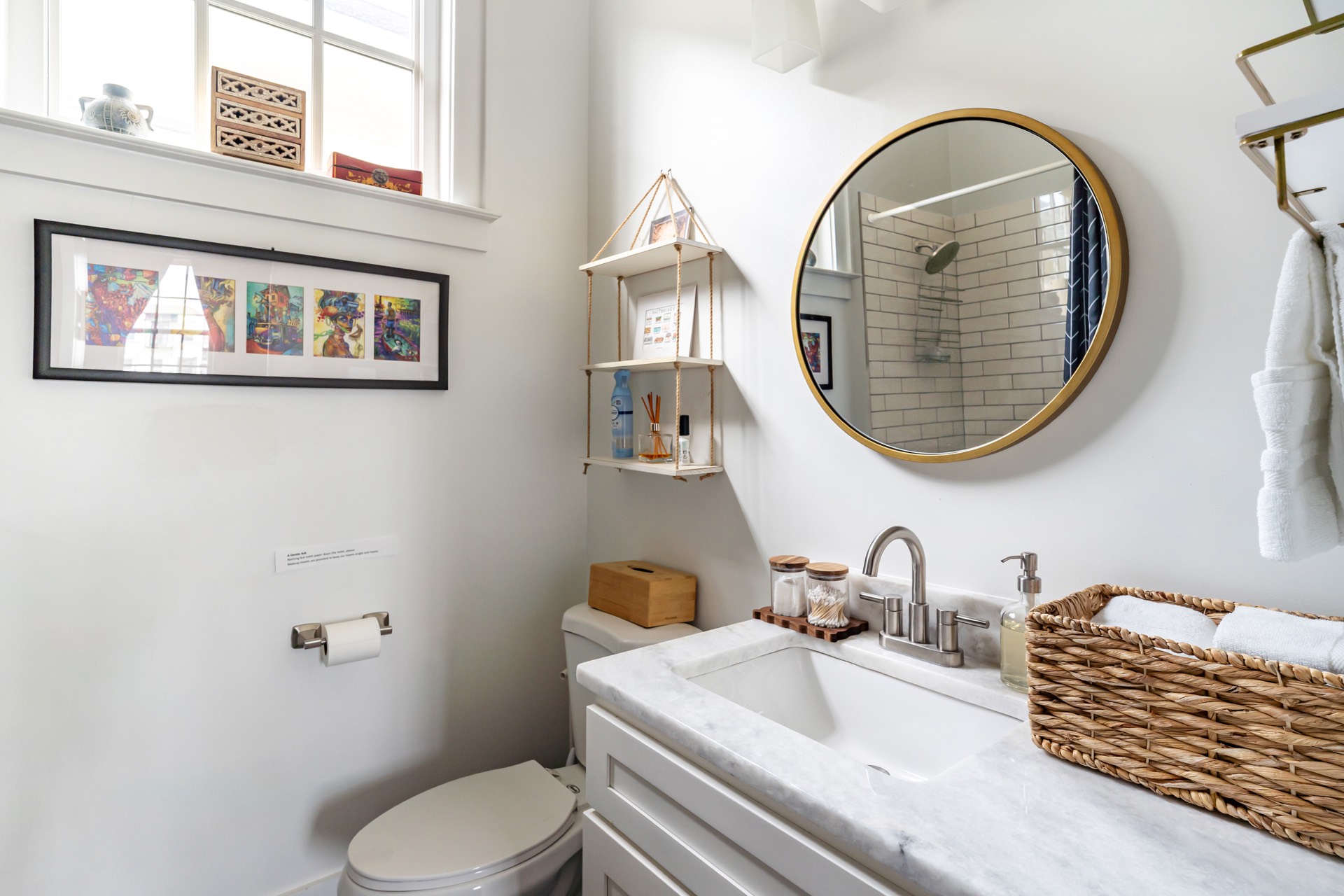 Half bathroom with gold mirror and art
