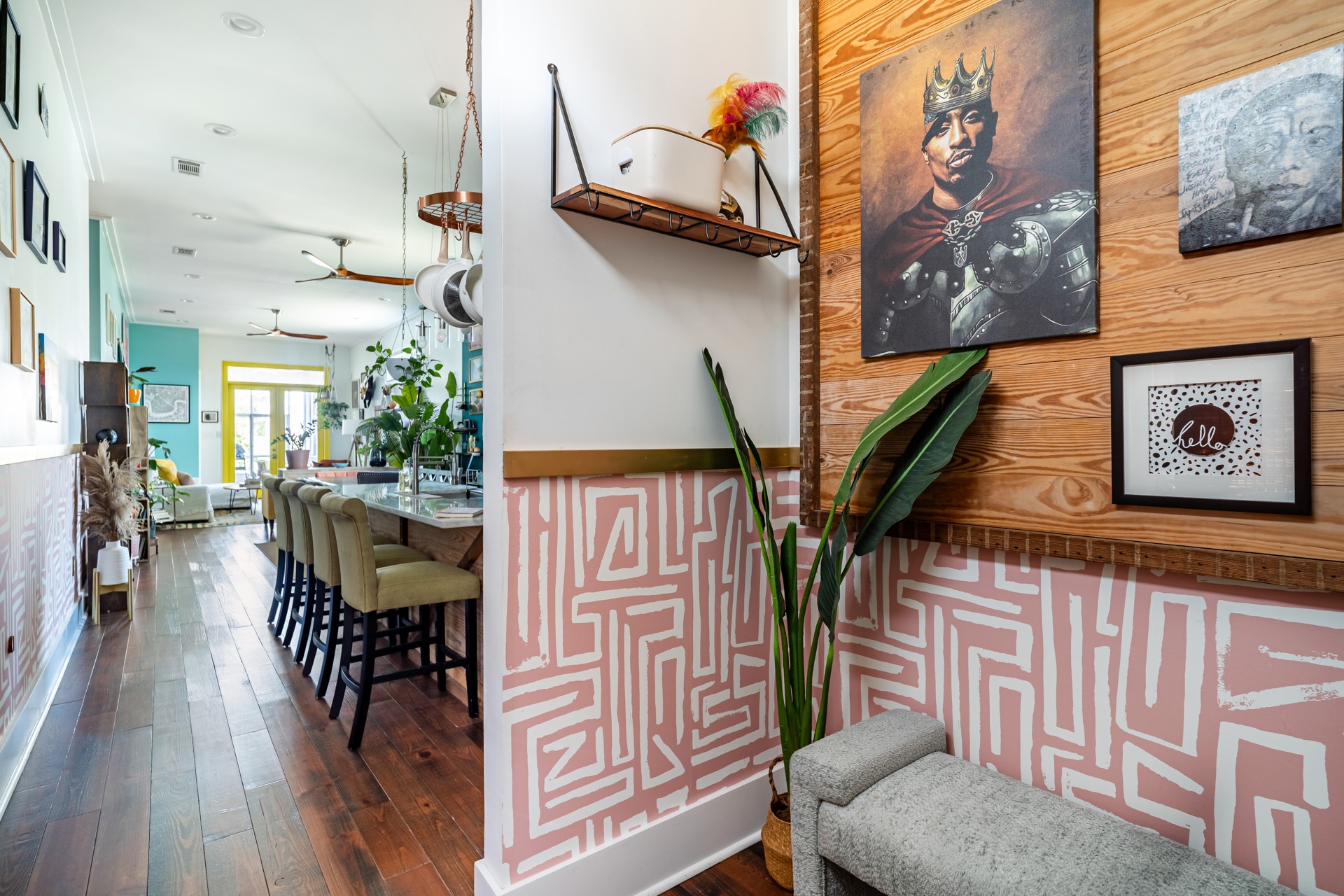 Entryway with pink patterned wallpaper and art