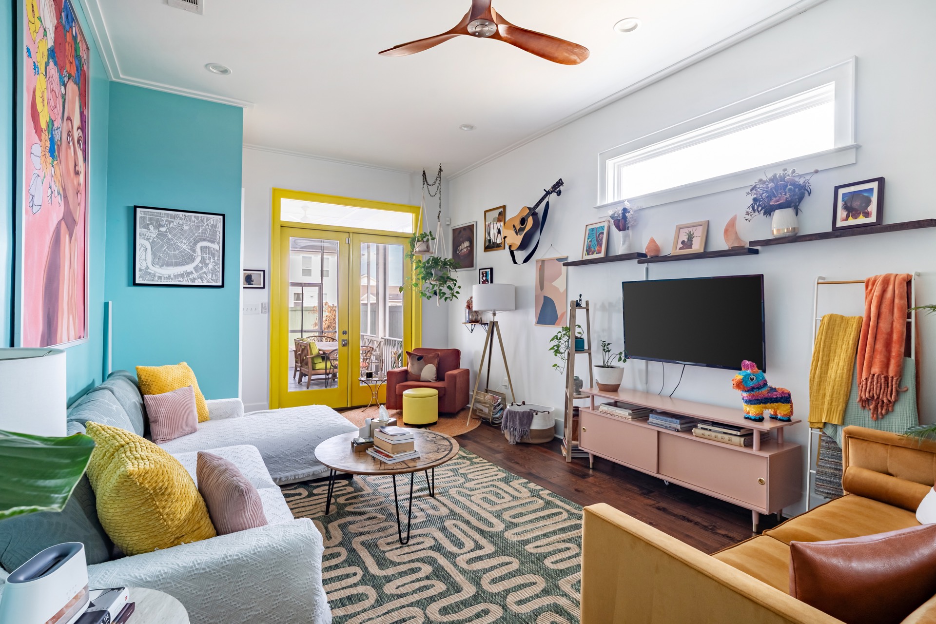 Living room with teal wall, yellow doors, and eclectic decor